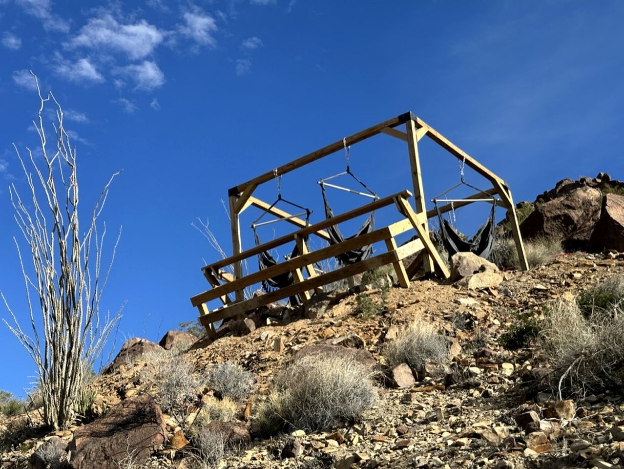Une structure en bois située sur une pente rocheuse, où la végétation est rare.