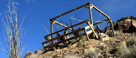 Une structure en bois située sur une pente rocheuse, où la végétation est rare.