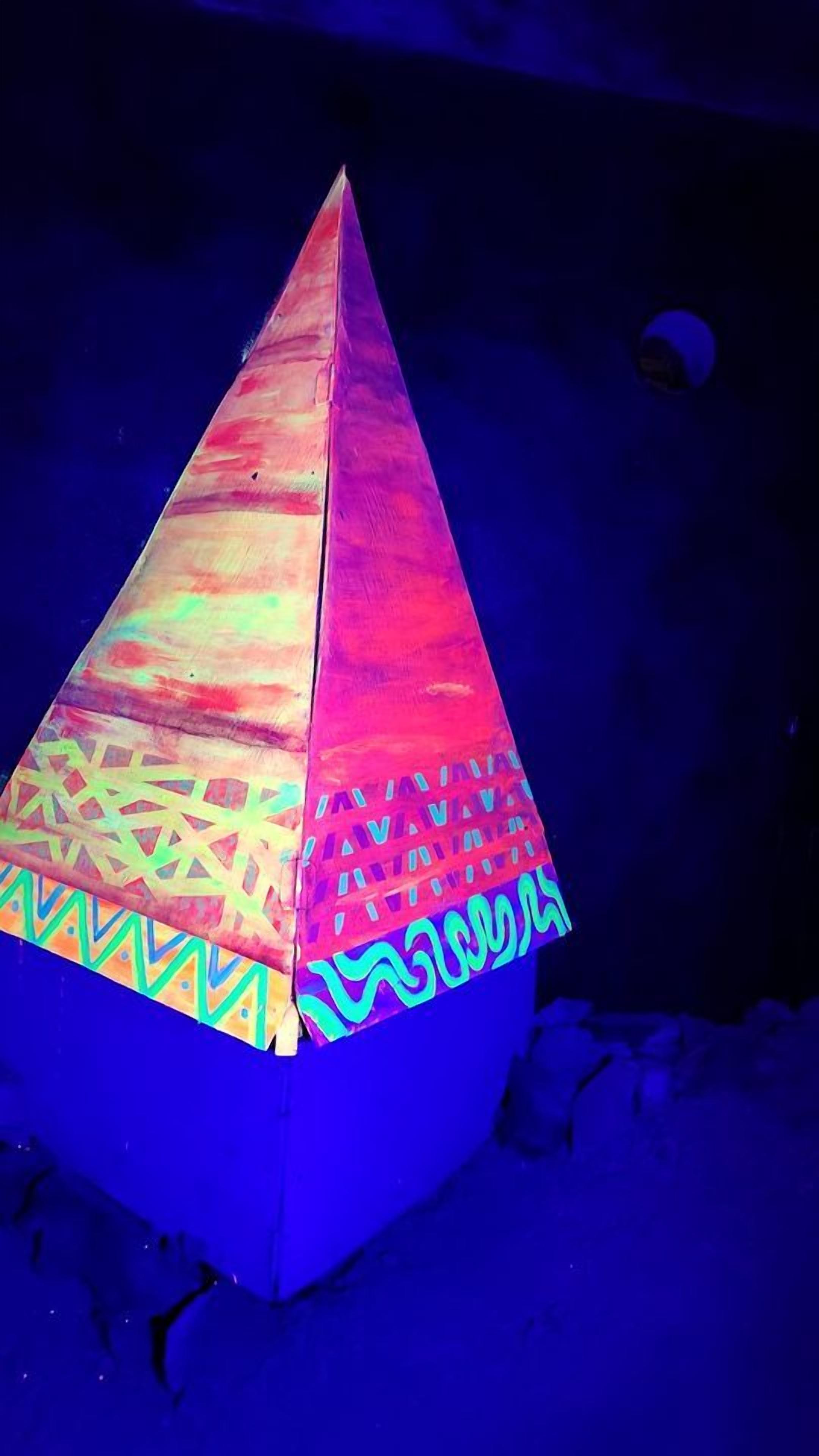 A pyramid-shaped structure with a geometric pattern on its base.