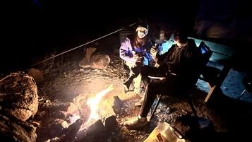 A group of people around a campfire at night.