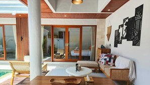 Un soggiorno moderno con un tavolo in legno, un divano e un'ampia finestra che si affaccia su un giardino.