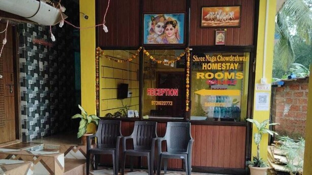 A reception area with a reception desk, chairs, and a patterned floor. - Naga Chowdeshwari Homestay (Kumta)