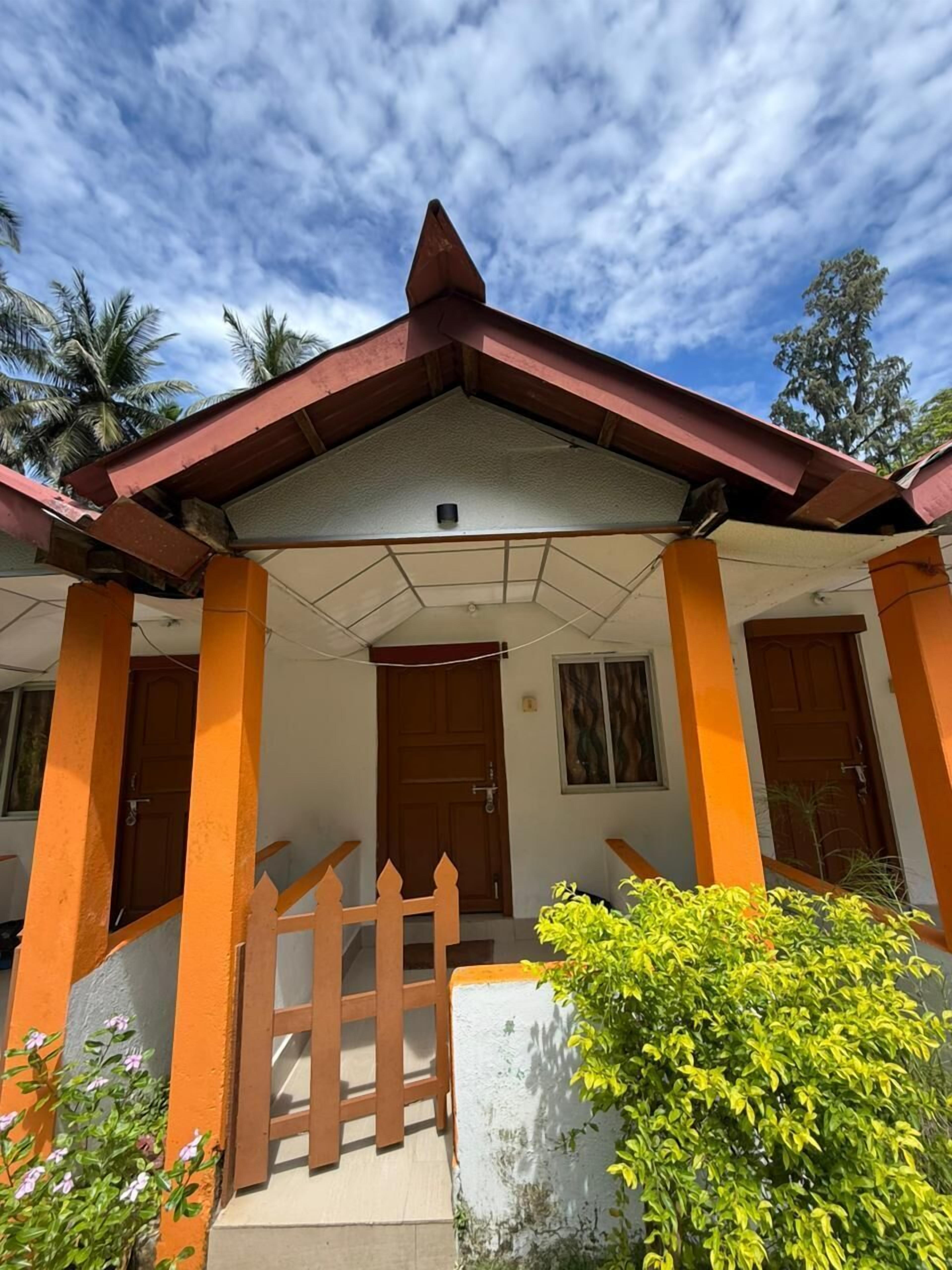 A building with a pitched roof, two doors, and a small porch area.