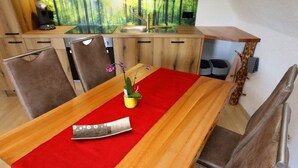 Een eetruimte met een houten tafel, een rode tafelkleed en een mes op de tafel.