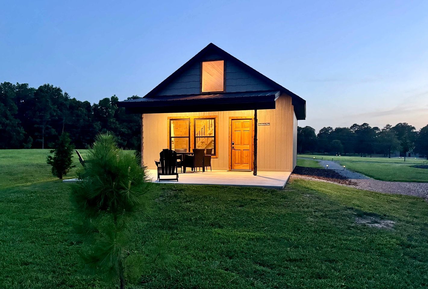 A single-story house with a porch, a dining area with chairs, and a door labeled 'Southern Pines.'