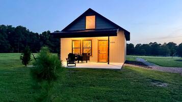 A single-story house with a porch, a dining area with chairs, and a door labeled 'Southern Pines.'