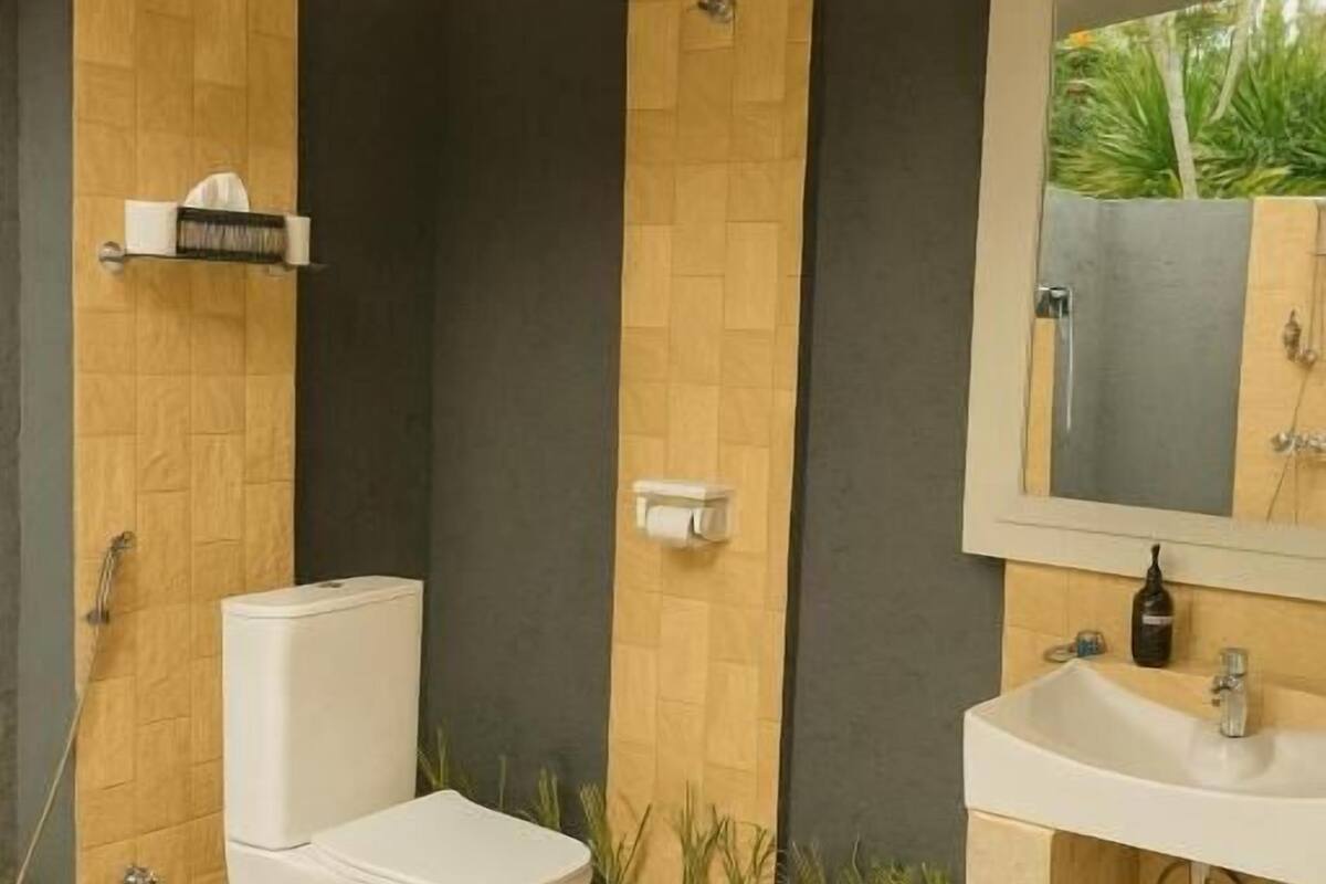 Une salle de bain avec des toilettes, un lavabo et une douche.