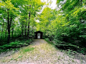 A forest path leading to a small cabin. - Cozy Cabin with Bunk Beds Surrounded by Nature near White Lake, Wisconsin (White Lake)