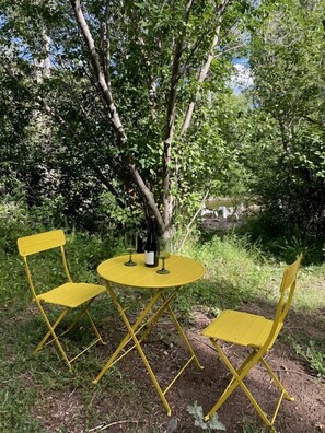 A yellow outdoor table and chairs set under a tree.