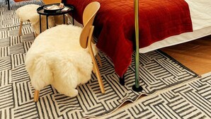 Ein Zelt mit Bett, Stuhl, kleinem Tisch und einem flauschigen weißen Sessel.