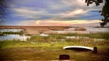 Un banco con vista a un paisaje pantanoso al atardecer.