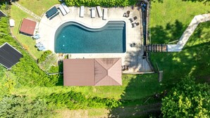 An aerial view of a residential property with a swimming pool, deck, and lounge chairs. - Incredible Riverfront Cabin Surrounded by Trees for an Unforgettable Escape in Nature in Blue Ridge, Georgia (Blue Ridge)