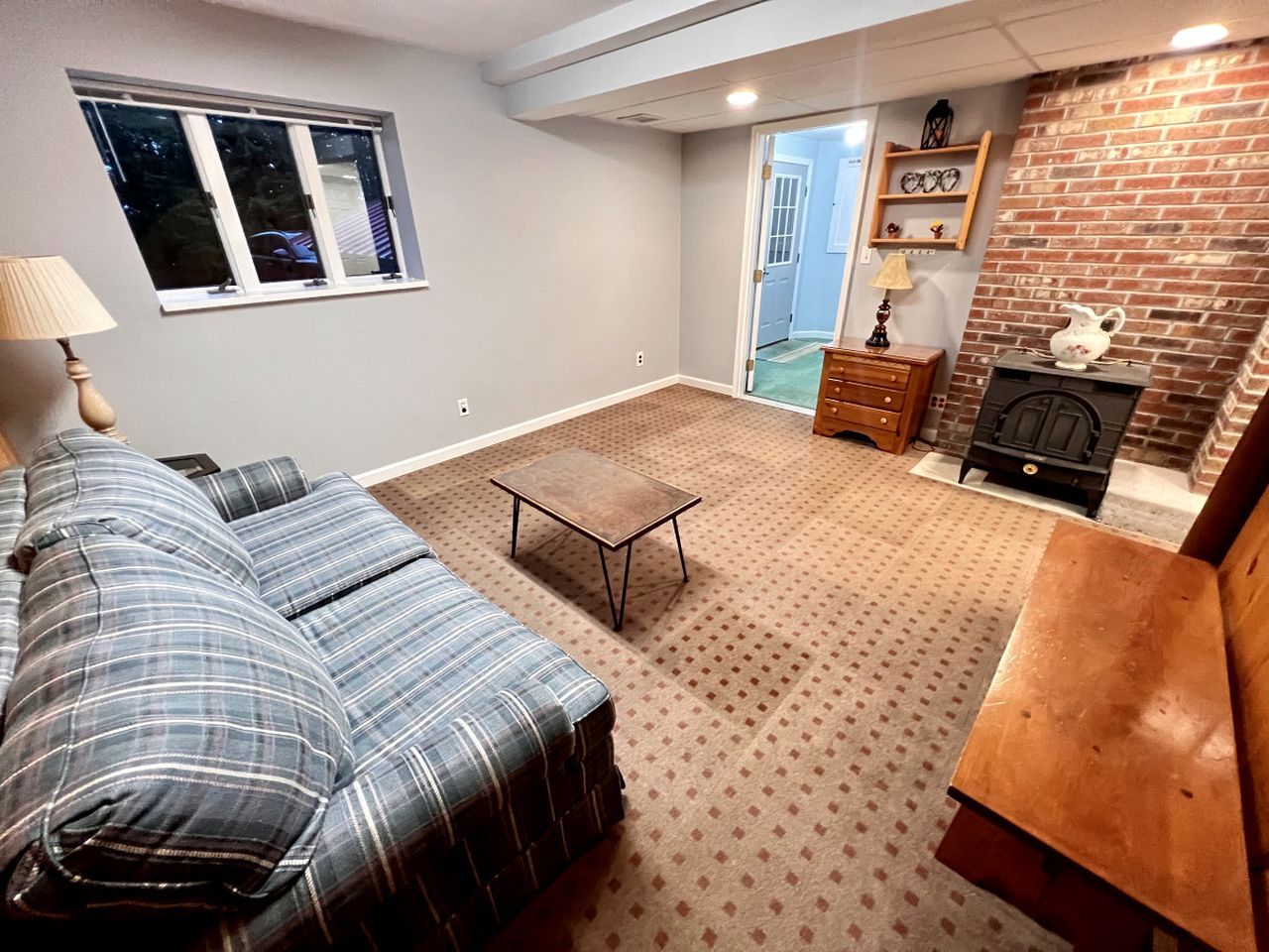 A cozy living room with a sofa, a coffee table, and a fireplace.