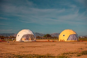 Two geodesic domes in a rural setting with mountains in the background. - Amazing Dome with the Greatest Desert Views Ever in Willcox, Arizona (Wilcox)