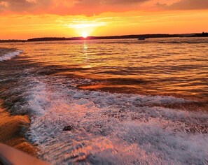 A sunset over a body of water with waves.