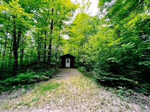 A forest path leading to a small cabin. - Romantic Cabin for a Cozy Escape in Nature near White Lake, Wisconsin (White Lake)