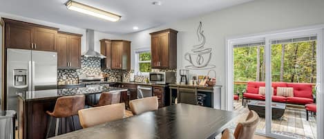 A modern kitchen with dark wood cabinets, stainless steel appliances, and a large island with seating.