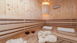 Puisesta laudelankkuineen ja pyyhkeineen varustettu sauna, ja seinällä on kaksi kelloa.