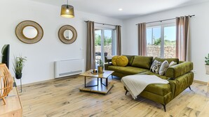 A modern living room with a green sofa, wooden coffee table, and decorative mirrors. - Villa Rea 4 with heated pool (Privlaka)