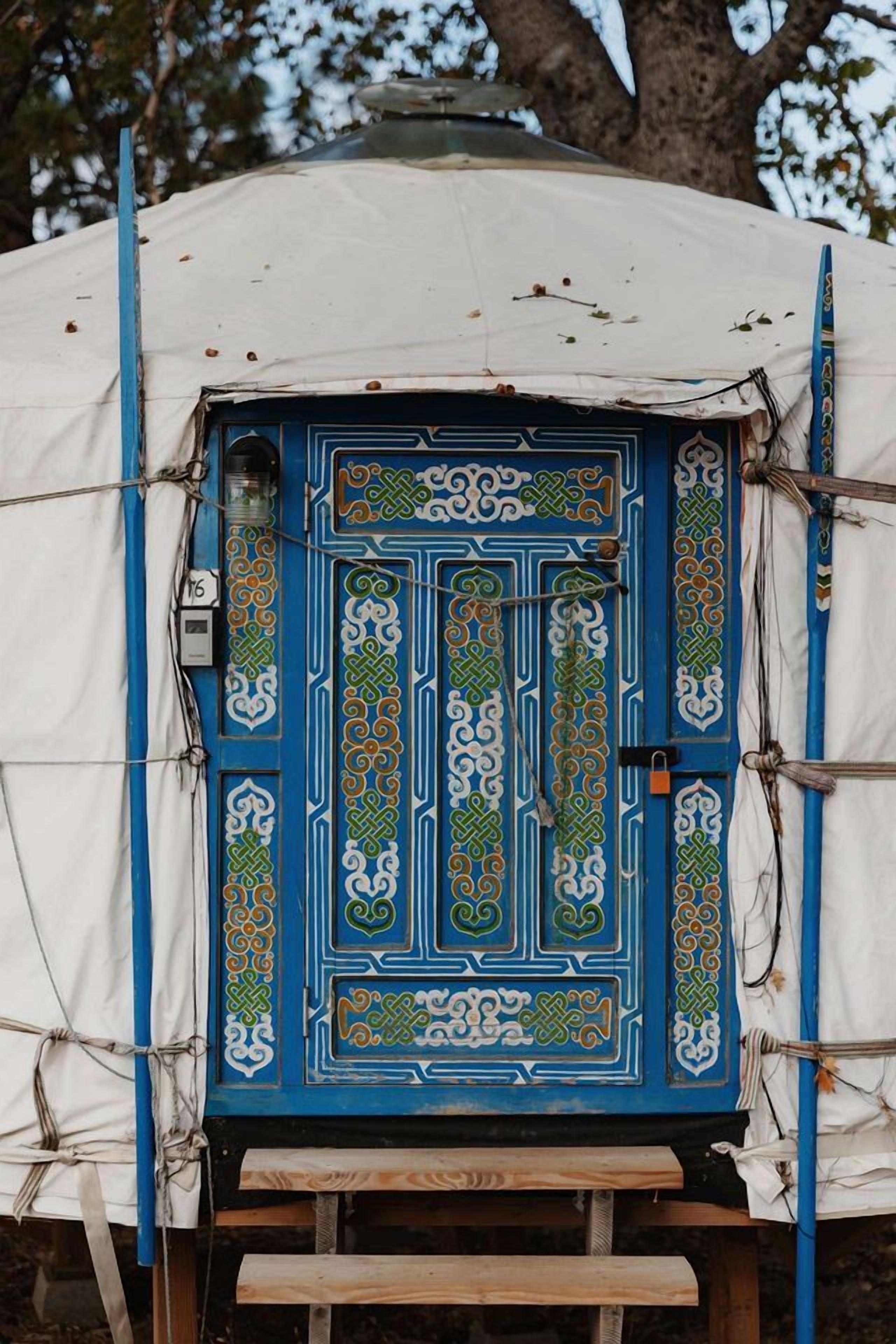 A tent with a decorative blue door featuring intricate patterns.