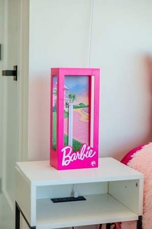 Una caixa rosa de Barbie sobre una prestatgeria blanca.