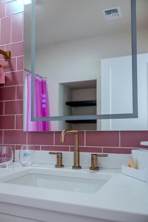 A bathroom with a white sink, a gold faucet, and a mirror above it. - Luminous Cozy Dome with a Barbie Collection Above Bed in Willcox, Arizona (Wilcox)
