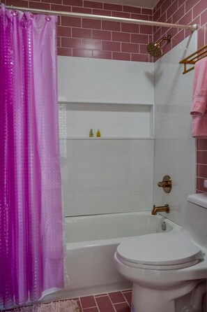 A bathroom with a shower, toilet, and a shelf with toiletries. - Luminous Cozy Dome with a Barbie Collection Above Bed in Willcox, Arizona (Wilcox)