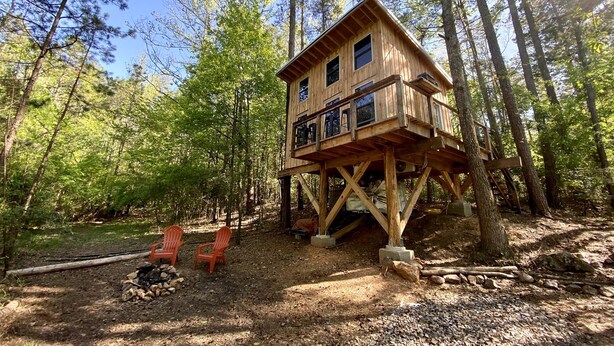 A wooden cabin elevated on stilts in a forest. - Luminous Peaceful Treehouse with Incredible Forest Views and Fire Pit in Arkansas (Boles)