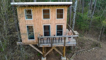 A wooden cabin with multiple windows and a deck.