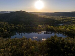 A lake surrounded by forested hills with a clear sky.
