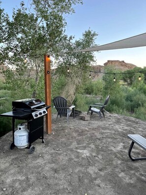 An outdoor patio with a grill, chairs, and a table. - Capitol Reef Glamping Getaway: Beautiful Pet-Friendly Dome near Hanksville, Utah (Wayne County)