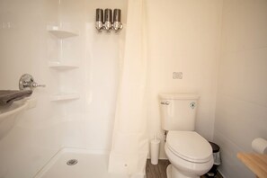 A bathroom with a toilet, a sink, a shower, and a towel rack.
