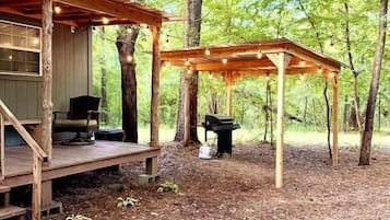 Eine Holzhütte mit Veranda und überdachter Außenbereich mit Sitzgelegenheit.