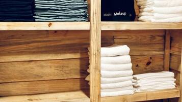 A wooden shelf with neatly folded towels and a black box with the text 'Make Makeup'.