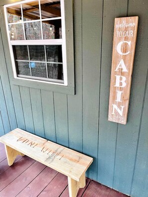 Un banc en bois et une pancarte de bienvenue pour un chalet.