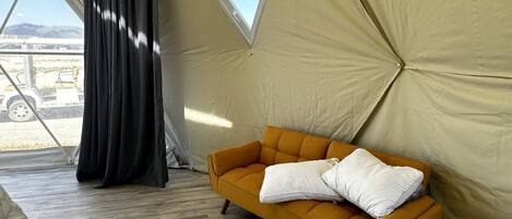A tent with a sofa and a window.