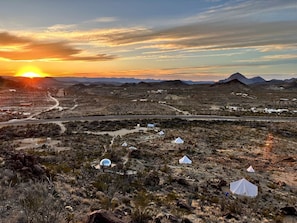 A desert landscape with tents and a road during sunset. - Impressive Dome with Great Panoramic Desert Views in Terlingua, Texas (Terlingua)