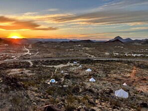 A desert landscape with tents and a road during sunset. - Impressive Dome with Great Panoramic Desert Views in Terlingua, Texas (Terlingua)