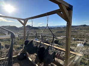 A wooden structure with two hammocks suspended from it, overlooking a mountainous landscape. - Impressive Dome with Great Panoramic Desert Views in Terlingua, Texas (Terlingua)