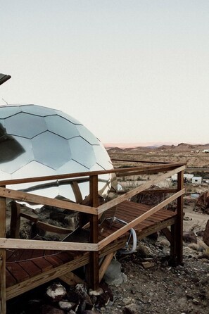 A wooden structure with a dome-shaped object, possibly a geodesic dome, and a wooden deck. - Impressive Dome with Great Panoramic Desert Views in Terlingua, Texas (Terlingua)