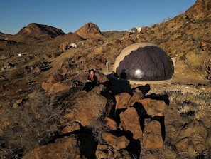 A dome-shaped structure in a desert landscape with rocky terrain and sparse vegetation. - Charming Cozy Dome in Terlingua, Texas (Terlingua)