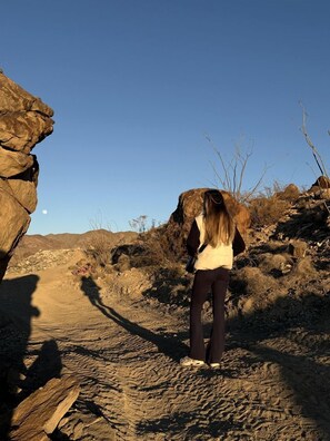 A person standing on a rocky path with a clear sky.