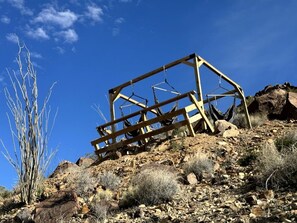 A wooden structure on a rocky hillside with sparse vegetation.