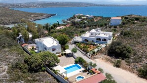 En fastighet vid kusten med flera byggnader, en swimmingpool och utsikt över havet.
