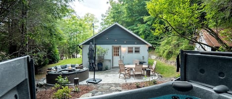 A backyard with a hot tub, outdoor seating, and a small shed.