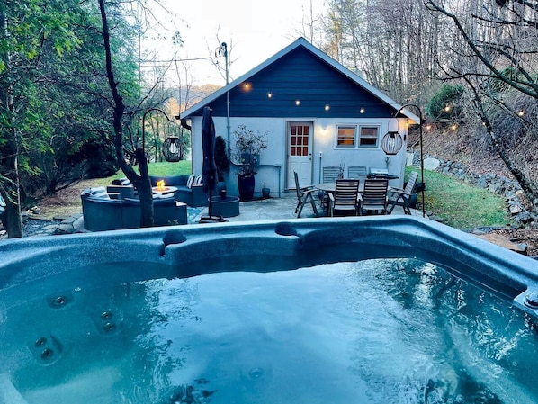 A hot tub with a house in the background.