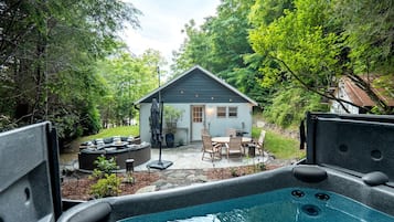 Un jardin avec un jacuzzi, un espace salon extérieur et un petit abri de jardin.