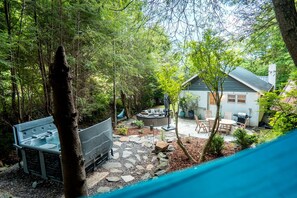 Un jardin avec un espace barbecue, une table à manger et une maison en arrière-plan.