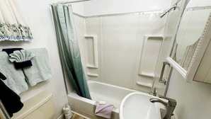Un baño con bañera, inodoro y lavamanos.
