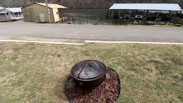 A pond with a metal structure in the center, surrounded by a grassy area with a gravel bed.